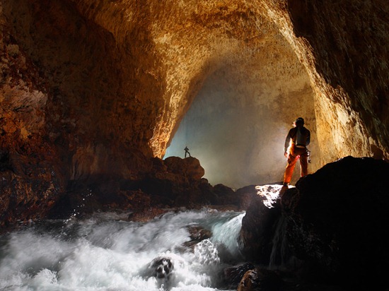 Cavers light the entrance passage of Ora Cave.